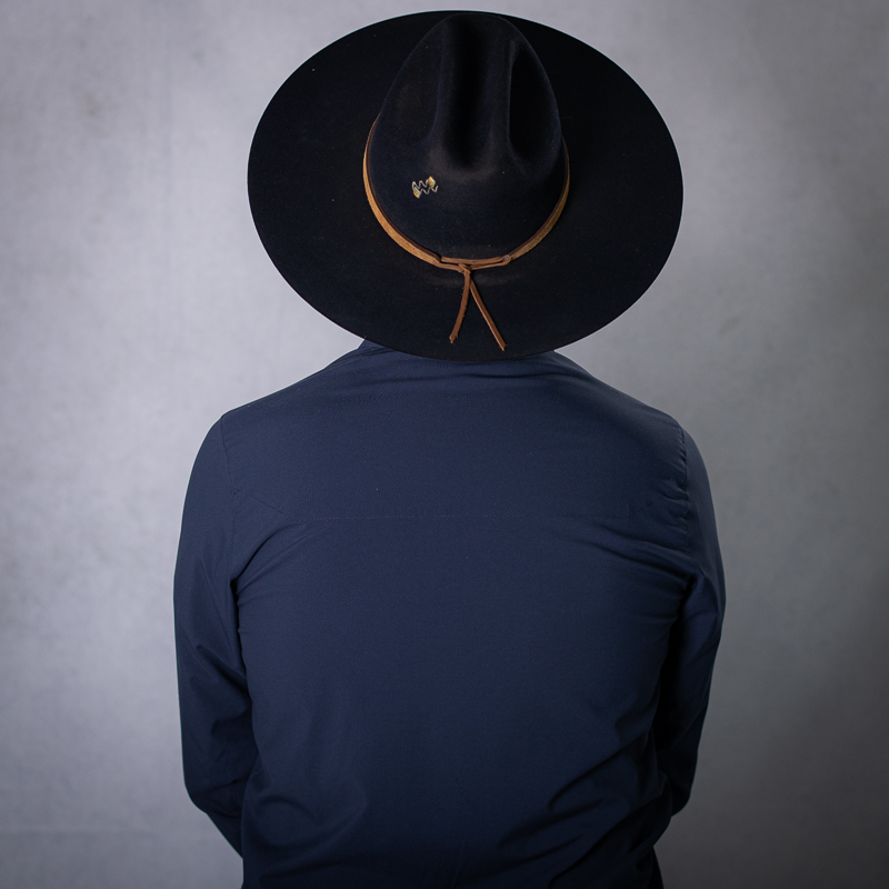 blue fedora hat, white mesh cap, black fedora hat hanging on black